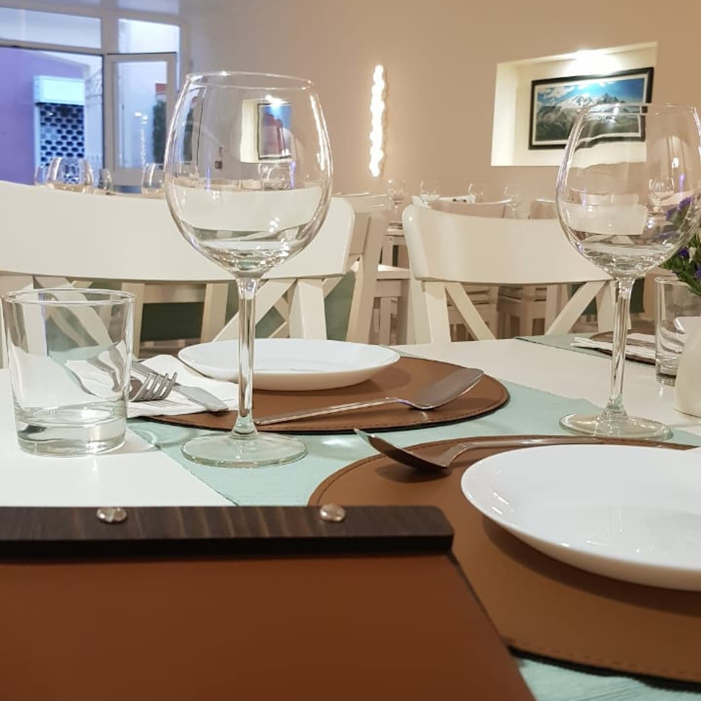 Mesa posta com vinho e taças à luz de velas