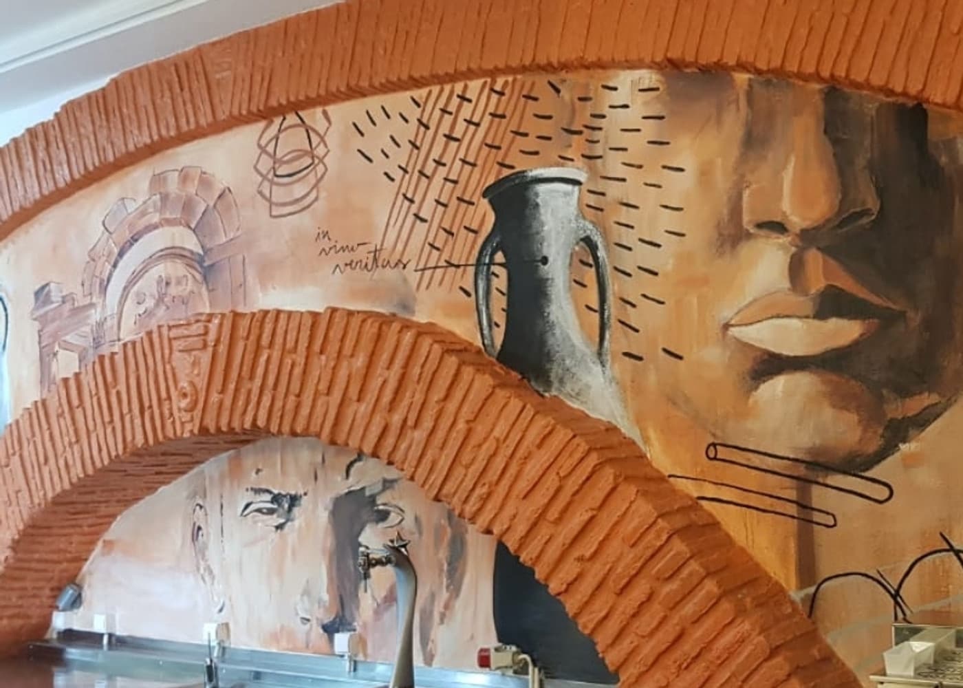 Mural artístico pintado à mão nos arcos de tijolo do restaurante
